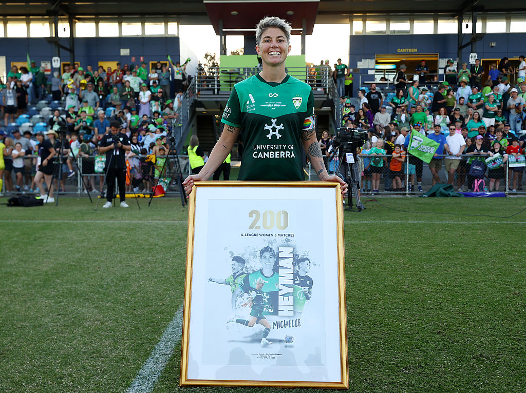 CANBERRA, AUSTRALIA - APRIL 13: Michelle Heyman of Canberra United is presented with a 200 Game Commemorative framed keepsake and Jersey After the round 22 A-League Women's match between Canberra United and Wellington Phoenix at McKellar Park, on April 13, 2025, in Canberra, Australia. (Photo by Mark Nolan/Getty Images)