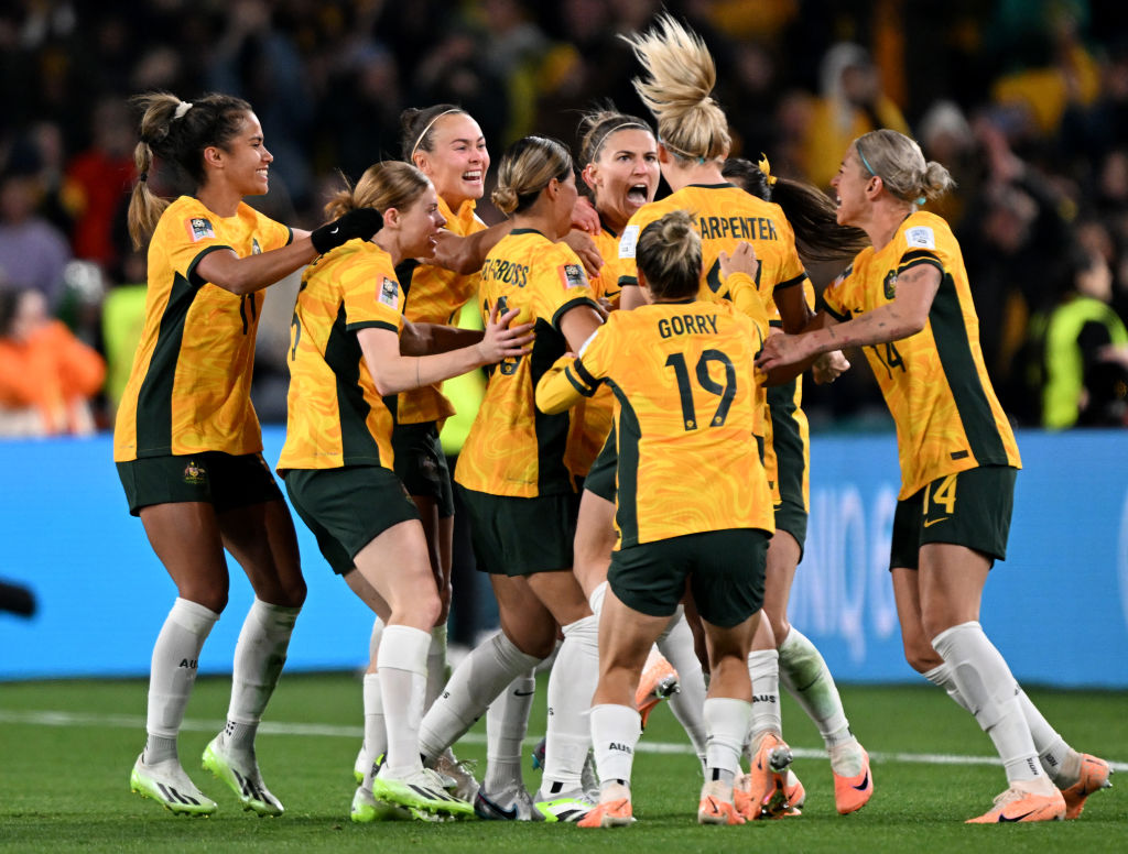 Australia players celebrate the team's first goal scored by Steph Catley (obscured) during the FIFA Women's World Cup Australia & New Zealand 2023 Group B match between Australia and Ireland at Stadium Australia on July 20, 2023 in Sydney, Australia. (Photo by Bradley Kanaris/Getty Images)