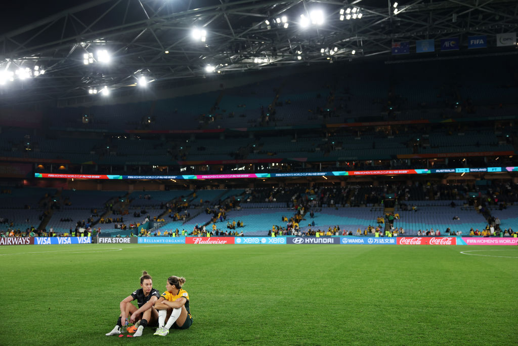 Mackenzie Arnold and Kyra Cooney-Cross of Australia react after the team's 1-3 defeat and elimination from the tournament following the FIFA Women's World Cup Australia & New Zealand 2023 Semi Final match between Australia and England at Stadium Australia on August 16, 2023 in Sydney, Australia. (Photo by Maddie Meyer - FIFA/FIFA via Getty Images)