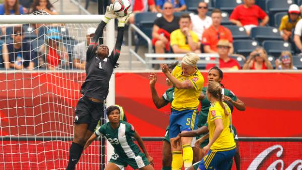 Nigeria's goalkeeper Precious Dede flies high to make a save against Sweden.